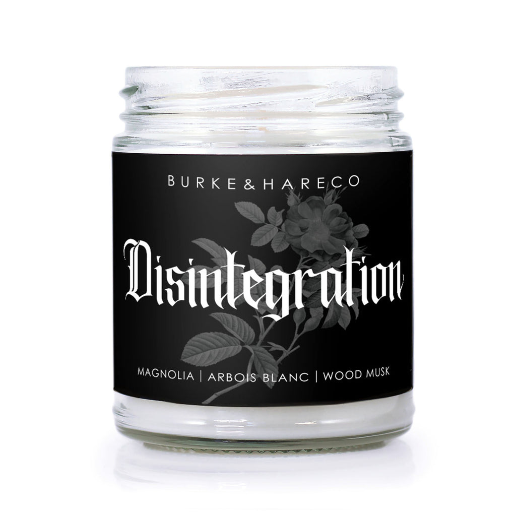 the Cure inspired candle with black label that has a flower on it and says Disintegration in white gothic font