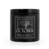 Halloween scented candle in a black tin with a black label that has a spooky skeletal tree on it and says October in white font