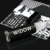 Goth perfume oil that smells like leather in a roll on vial with a black label and white text that says Widow.