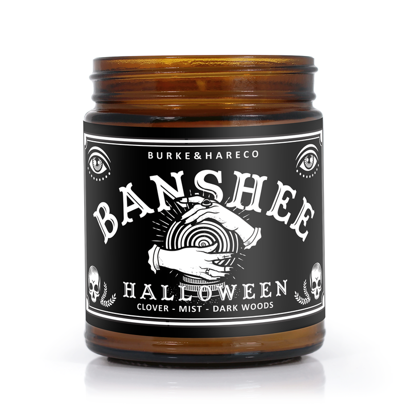 Unique Halloween scented candle has a black label with the graphic of witchy hands holding a crystal ball on it and says "Banshee" in white ouija lettering