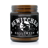 Witchy scented candle has a black label with a graphic witch against the moon on it and says "Bewitched" in white ouija lettering