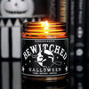 Lit Witch themed scented candle has a black label with a graphic witch against the moon on it and says "Bewitched" in white lettering.