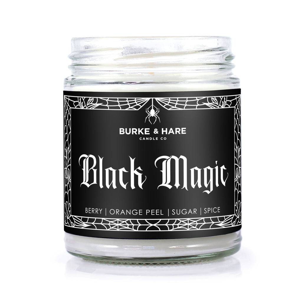 Halloween themed scented candle in glass jar with black label that reads Black Magic in white gothic font