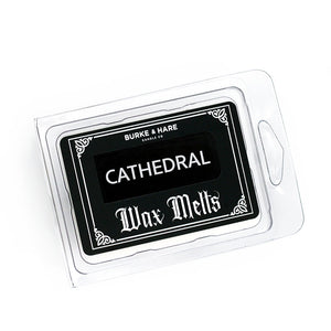 church scented wax melts in clear clamshell container with a black label that has gothic details on it and white text that says Cathedral.