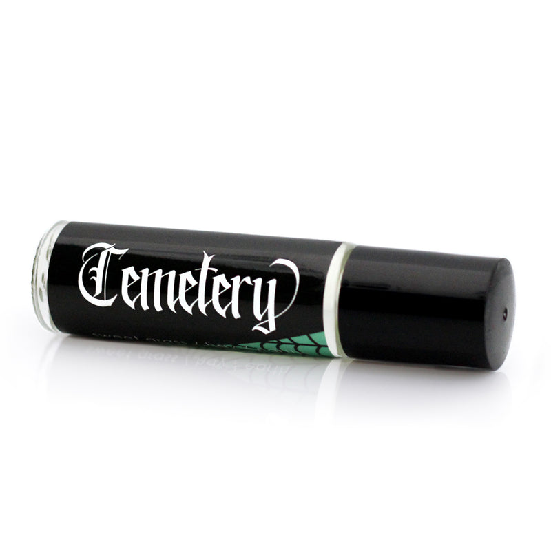 Graveyard scented perfume with a black label that features a spiderweb on half over a green background.