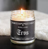 lit candle with black label and gothic spiderweb boarder that says Eros in white text.  
