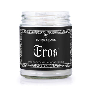 Chocolate scented candle for valentine's day with a black label that has gothic spiderweb boarder and white text that says Eros