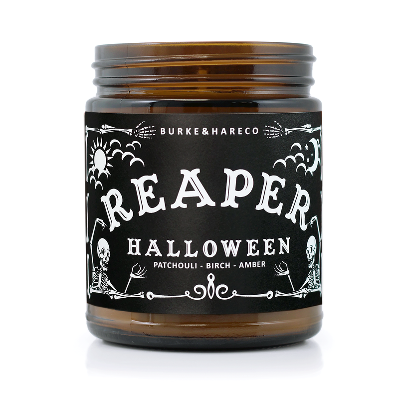 Unique Halloween scented candle has a black label with graphic skeletons on it and says "Reaper" in white ouija lettering