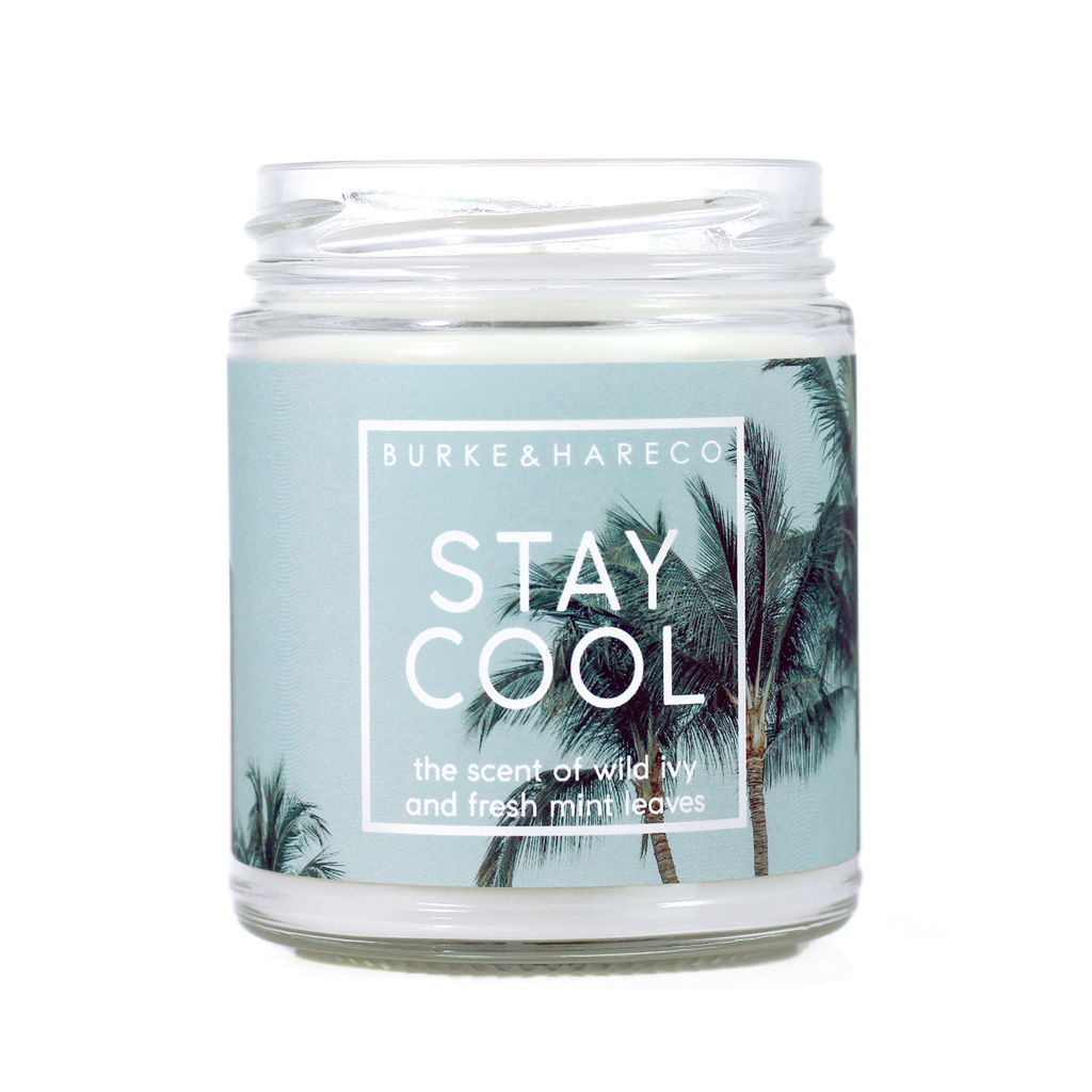 mint scented candle for summer with palm trees on light green label and white text that says "stay cool"