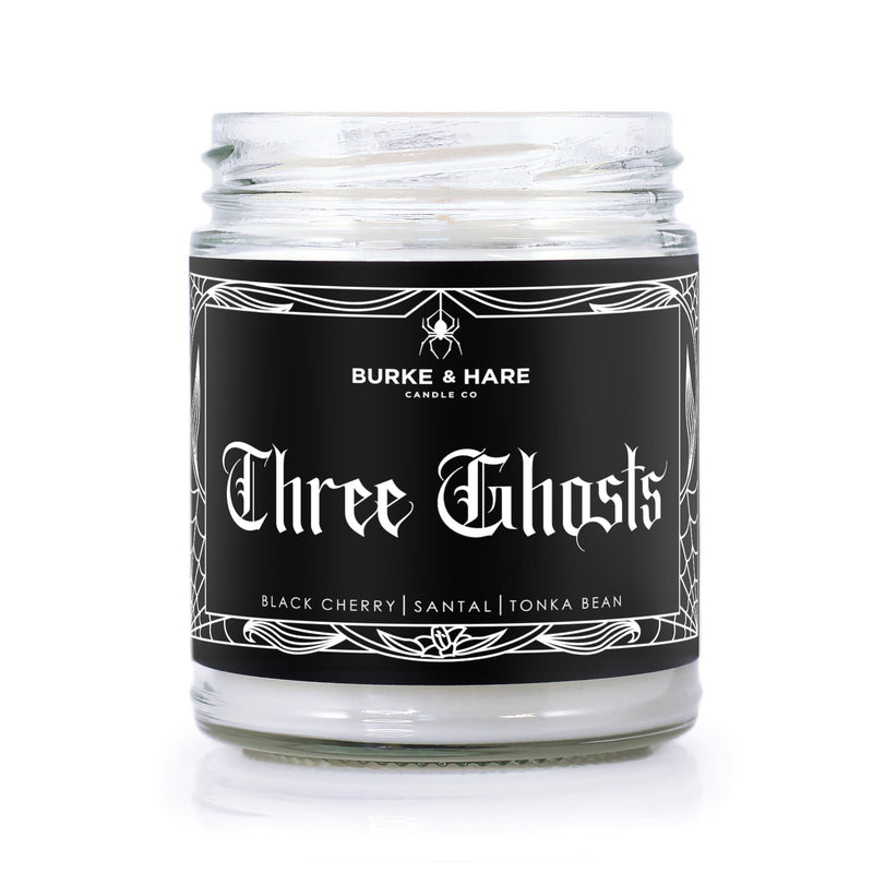 Cherry scented christmas candle with black label and white text that reads 