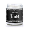 sandalwood scented candle with black label that has a spiderweb border and reads Violet in gothic font. 