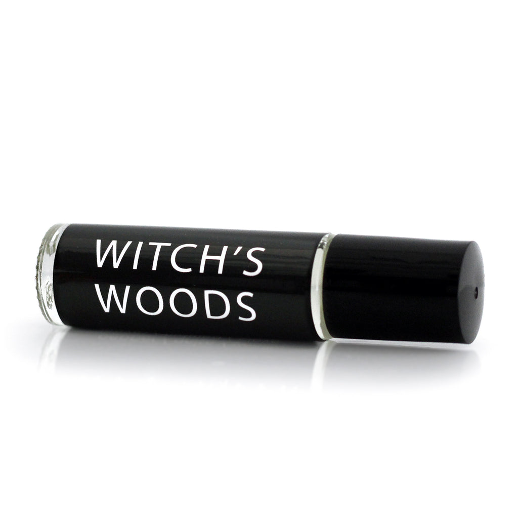 Gothic Perfume oil in a roller vial with a  black label and white text that says "Witch's Woods"