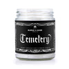Graveyard scented candle with a gothic label that has white spiderweb border and white text that reads "Cemetery"
