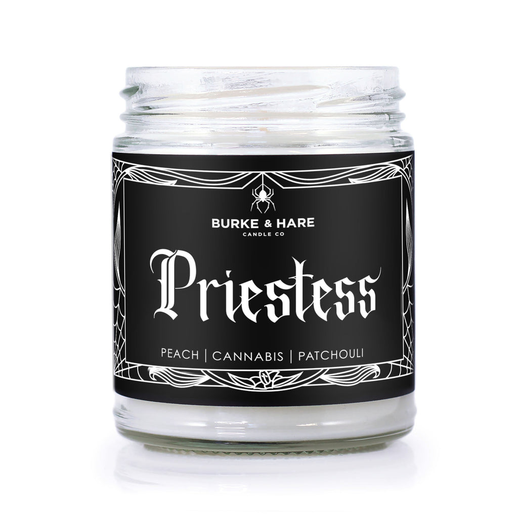 gothic scented candle with black label and spiderweb border. Text says "priestess" in gothic font