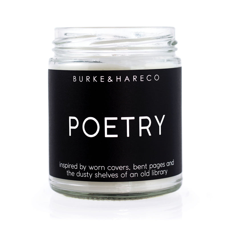 Book scented candle with black label and white text that says Poetry and in small font reads 