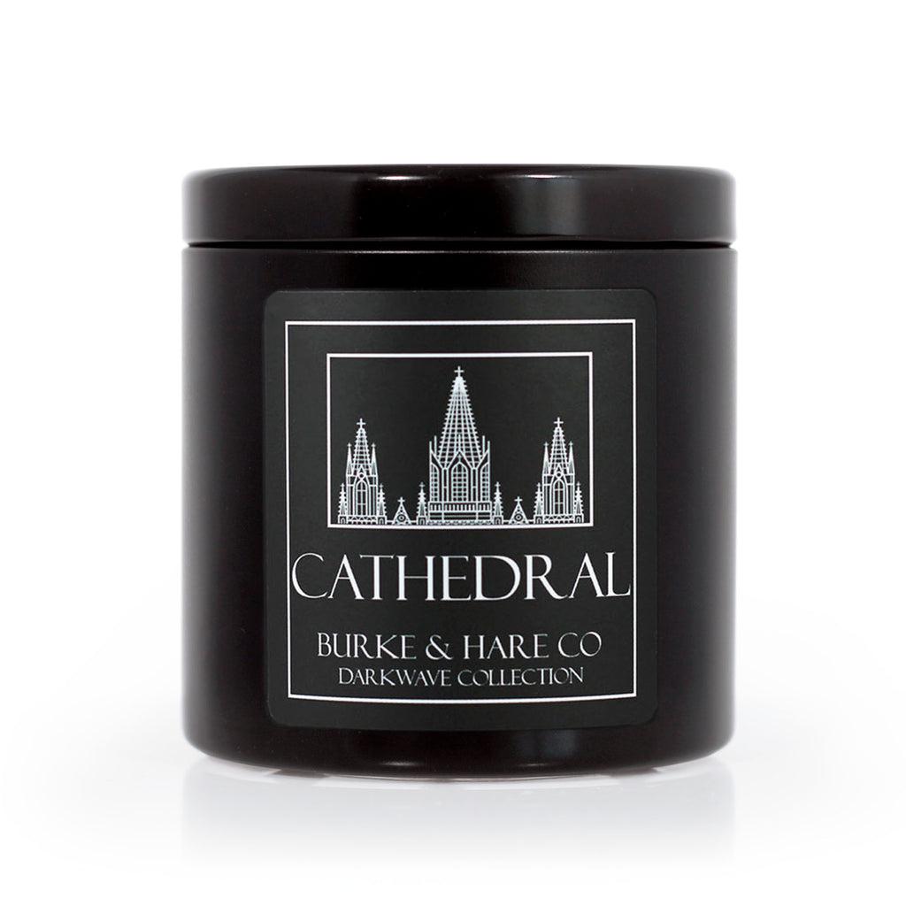 Gothic black candle in a black tin, the label has an illustration of a church. 