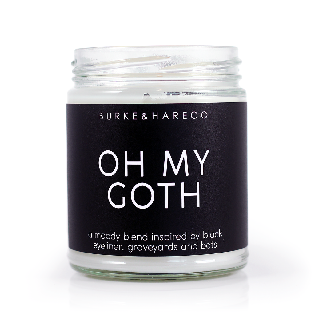 Goth scented candle with black label and white text that says Oh My Goth