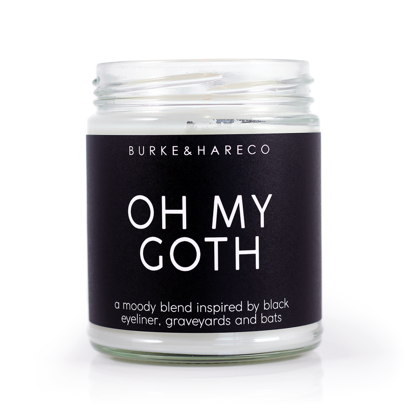 scented candle with black label and white font that reads Oh My Goth sitting on an image of a goth model 