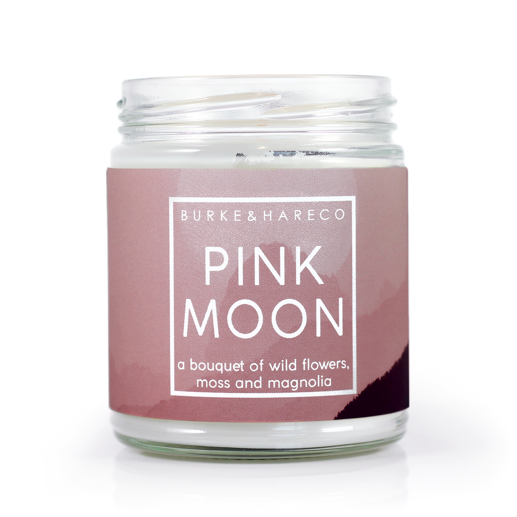 Floral scented candle for spring with a pink pastel label and white text that says Pink Moon