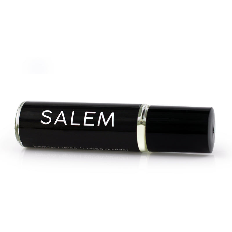 Handmade perfume oil in a roll on vial with a black label and white text that reads Salem