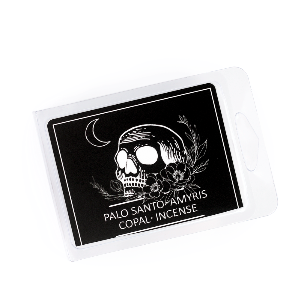 tarot card inspired wax melts scented with palo santo and incense with a black label featuring an illustrated skull and crescent moon
