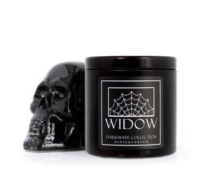 Goth scented candle in a black tin with a black label that has a spider web on it and reads WIDOW in white text next to a glass skull. Gothic Home decor