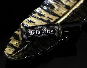 Smoke scented perfume oil in a roll on vial with a black label and white text that says Wild Fire in only english font