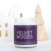 velvet woods soy scented candle with purple label in a holiday scene